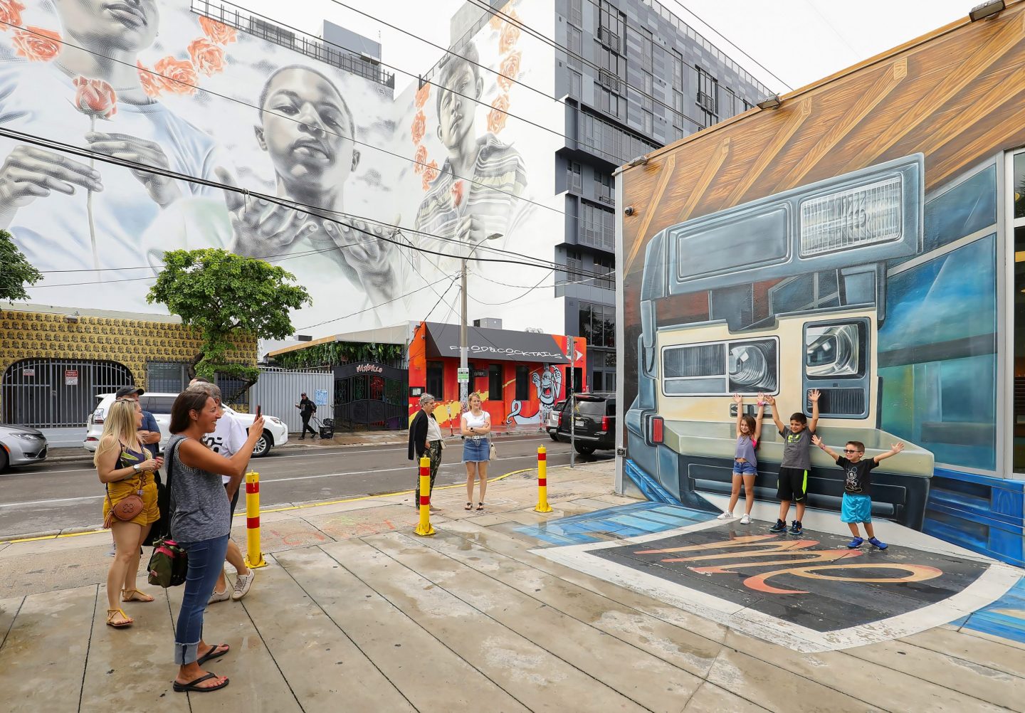 Miami, Florida, USA - December 28, 2019: Mom takes photos of her kids in front of a building ay Wyndwood.